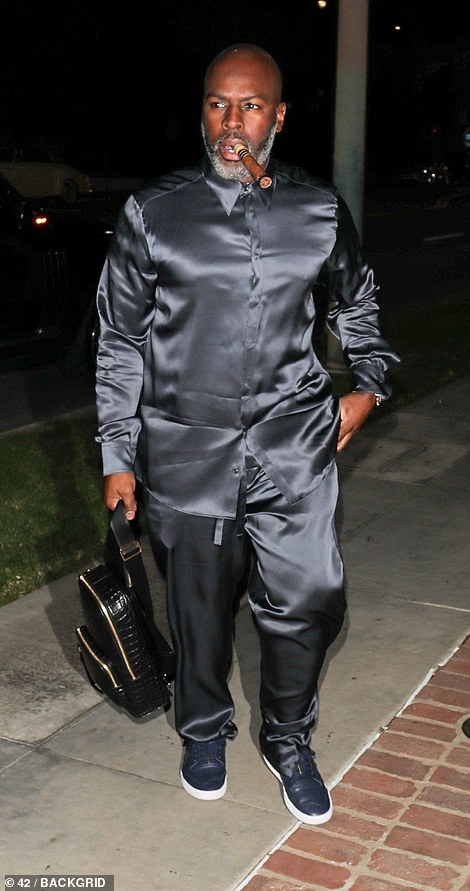The tour manager and entrepreneur wore a black silk co-ord and was seen with a cigar in his mouth