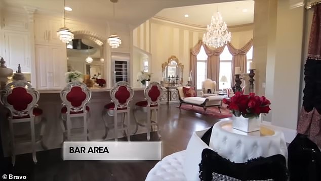 A full-size bar features floor-to-ceiling woodwork with a wine refrigerator, ice maker, dishwasher and drink cooler