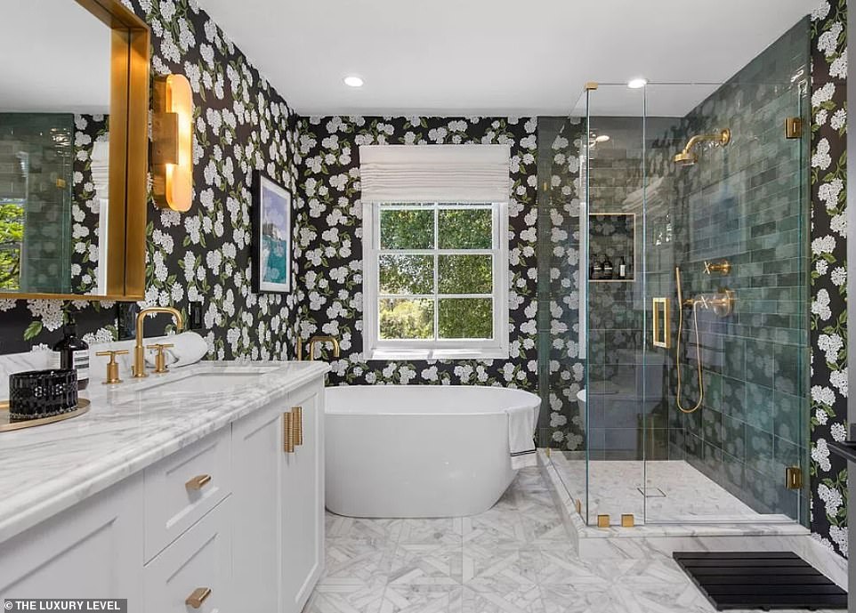 Inside, a formal living room sets the stage with its elegant ambiance, complemented by designer wallpaper and intricate tiling in each bathroom, adding a touch of luxury throughout