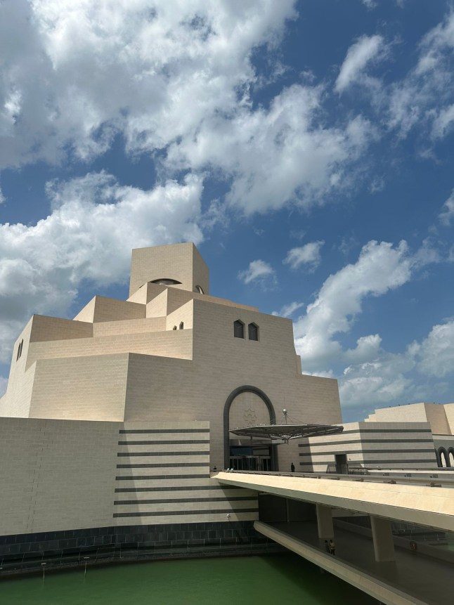 The Islamic Museum of Art in Doha, Qatar. It is a white cuboid building with a bridge leading out to it over water