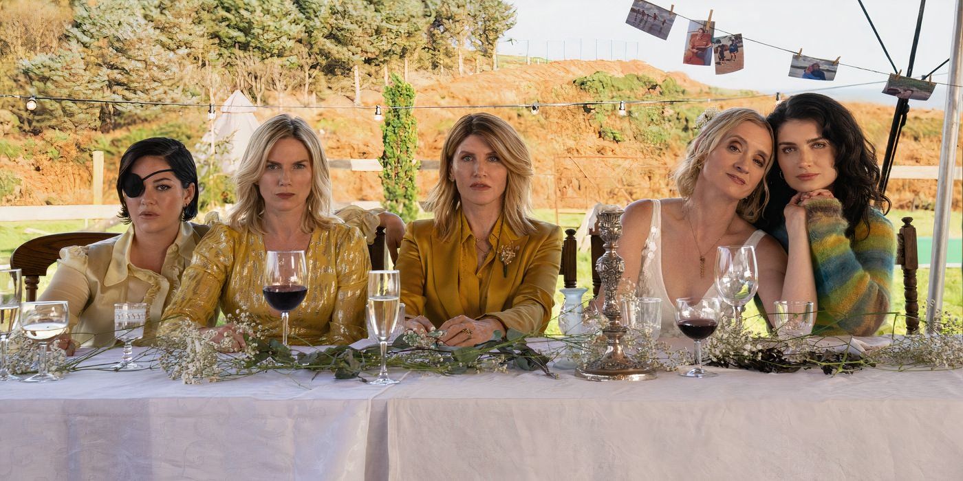 The Garvey sisters sit outside at a table wearing white and yellow in 'Bad Sisters' S2 image.