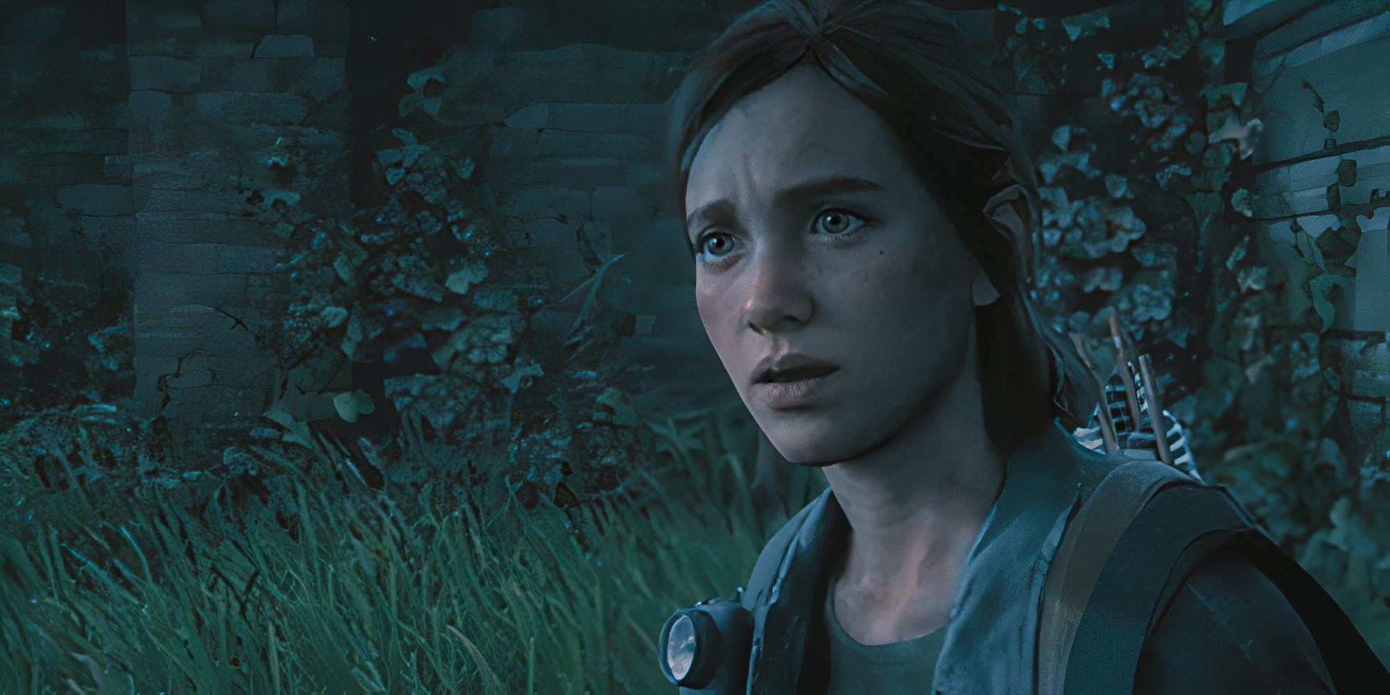 A worried Ellie standing near overgrown grass and a brick building in The Last of Us Part II