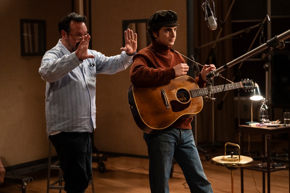 James Mangold directing Timothée Chalamet playing guitar in a recording studio.