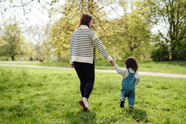 Young Asian mother enjoying family time with her toddler in nature