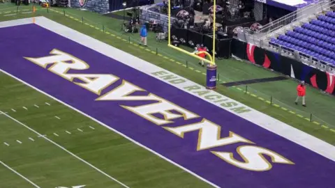 Getty Images A NFL end zone showing the Ravens text logo and the slogan 'End Racism' stencilled on the edge of the field.