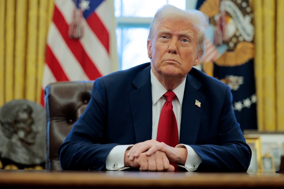 President Donald Trump seated at his desk in the Oval Office.