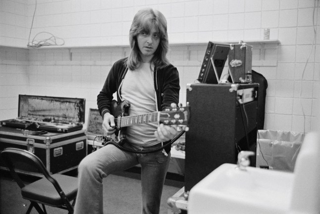 SPRINGFIELD, USA - 1st AUGUST: guitarist Joey Molland from Natural Gas (and ex Badfinger) tunes his guitar backstage in Springfield, Massachusetts in August 1976. (Photo by Fin Costello/Redferns)