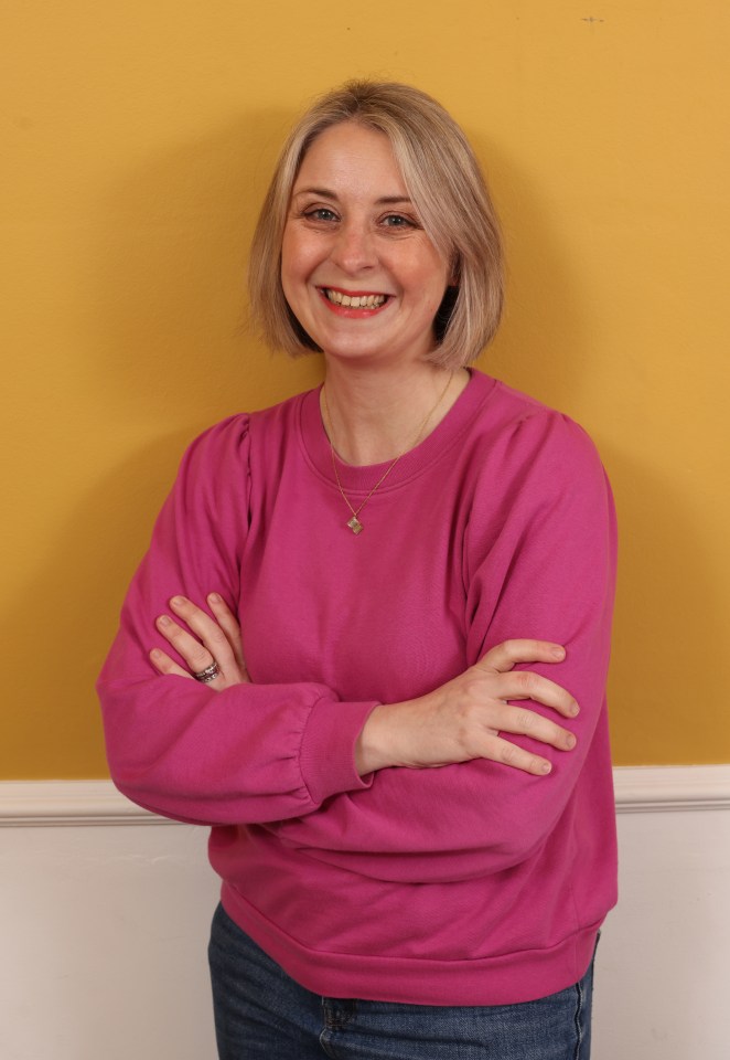 Portrait of a smiling woman with arms crossed.