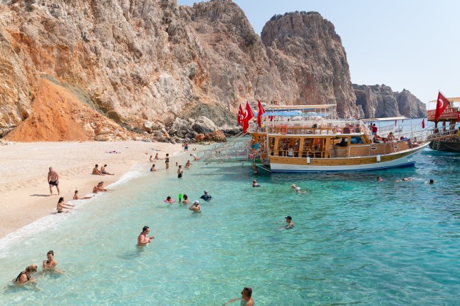 People swimming in the clear waters of Suluada island.