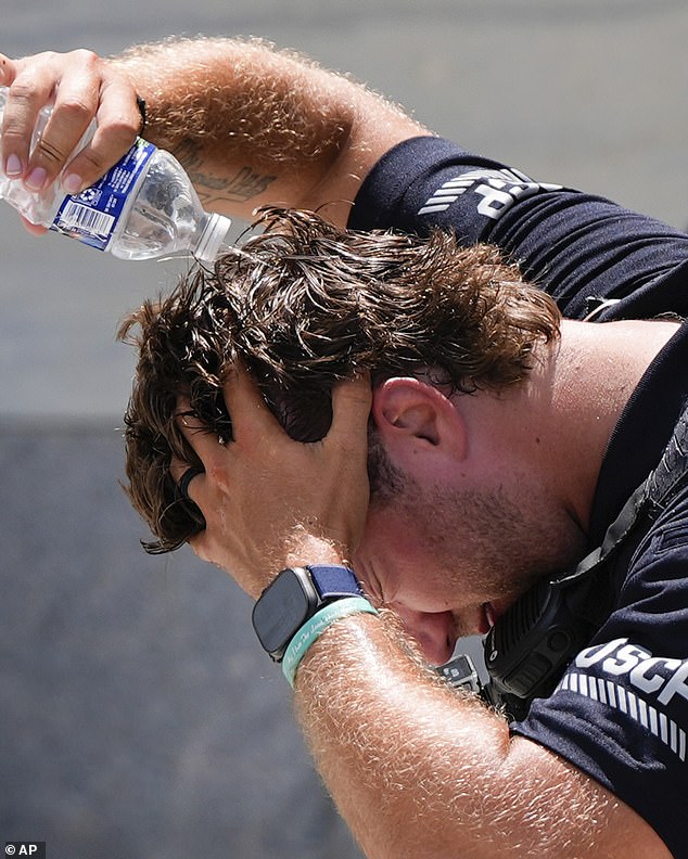 A US Capitol Police officer pours water over his head to cool down as sweltering heat grips Washington, DC. Thursday marked the seventh straight day of dangerous temperatures across the East, with heat indexes soaring past 100 degrees and little relief in sight