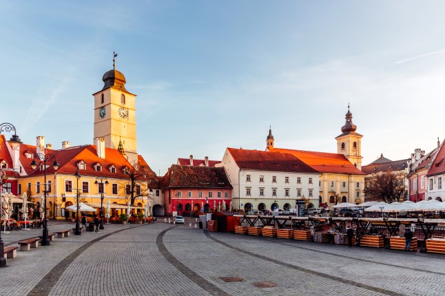 Grand Square in Sibiu, Romania, featuring cobblestone streets and coloured houses.