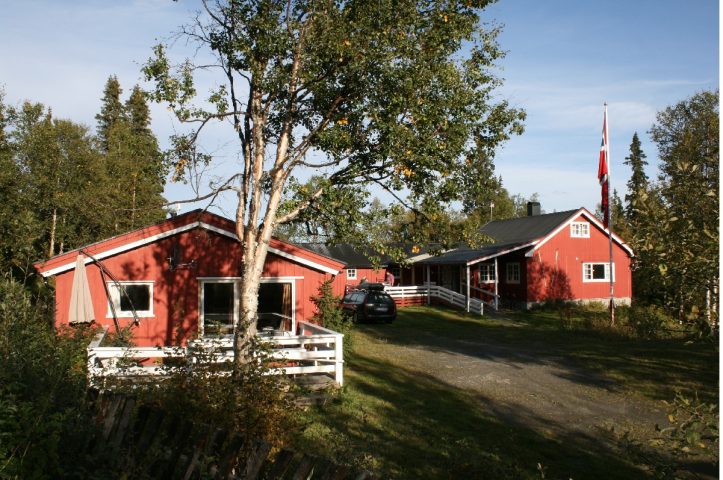 Hyttene på Vaset sett forfra ved porten. Lillehytlehytta til venstre og hovedhytta til høyre.