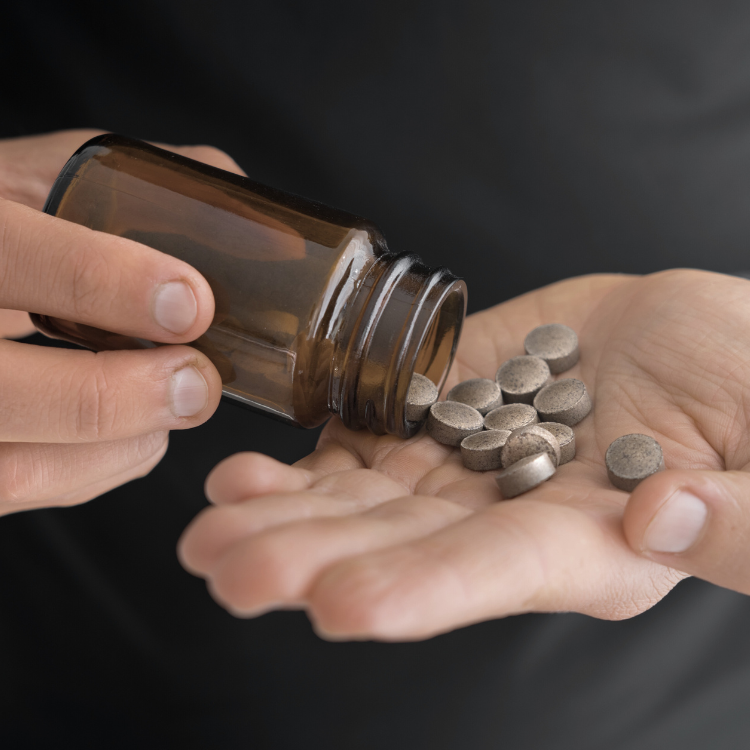 Man taking vitamins from a bottle