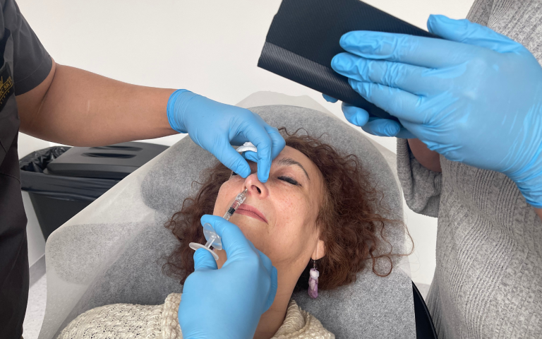 woman getting filler injection treatment done by a doctor