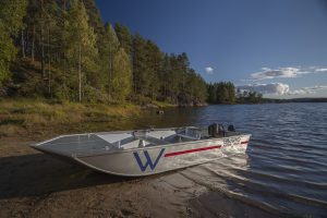 Norwegian Camper som båt, ligger ved en strand.