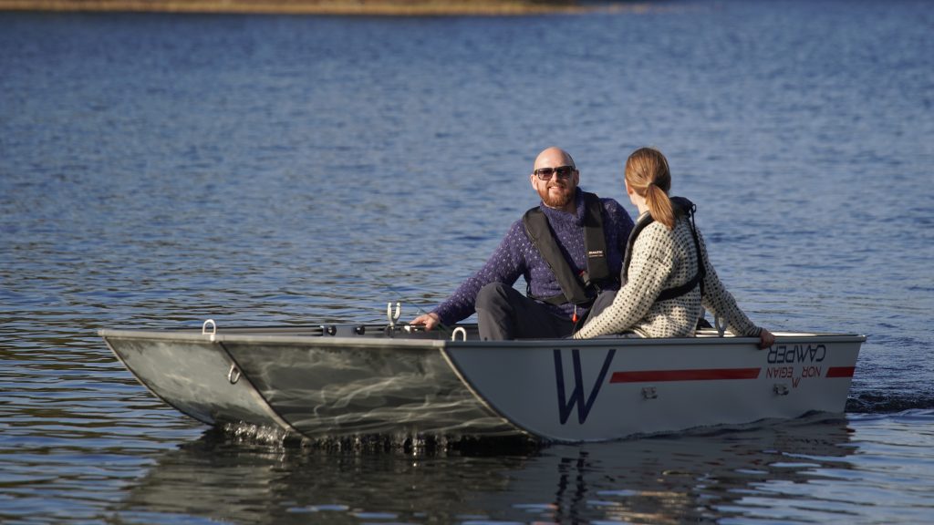 Mann og kvinne på båttur i Norwegian Camper.