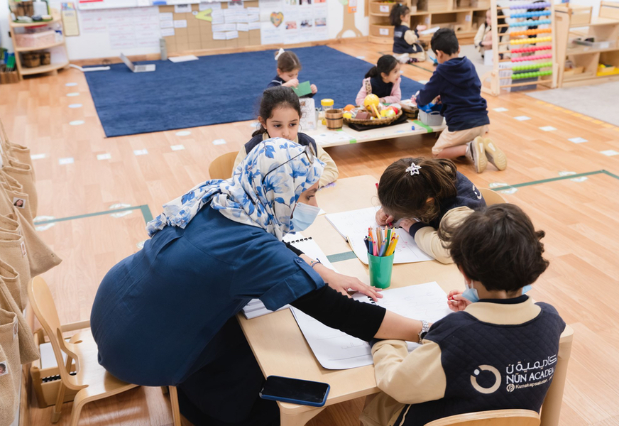 Students working with their teacher in the classroom