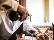 crop man pouring red wine in glass in restaurant