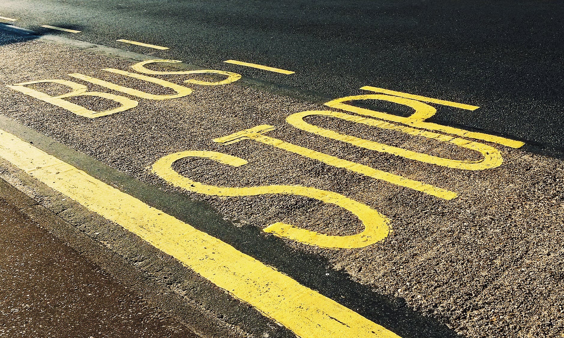 bus stop printed on asphalt road