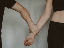 crop man grasping hand of woman