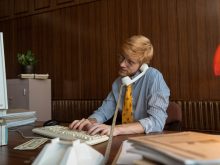 a businessman typing on laptop while on a phone call