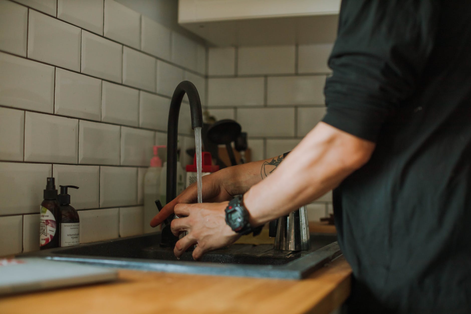 person getting water from a faucet