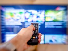 a close up shot of a person using a tv remote controller