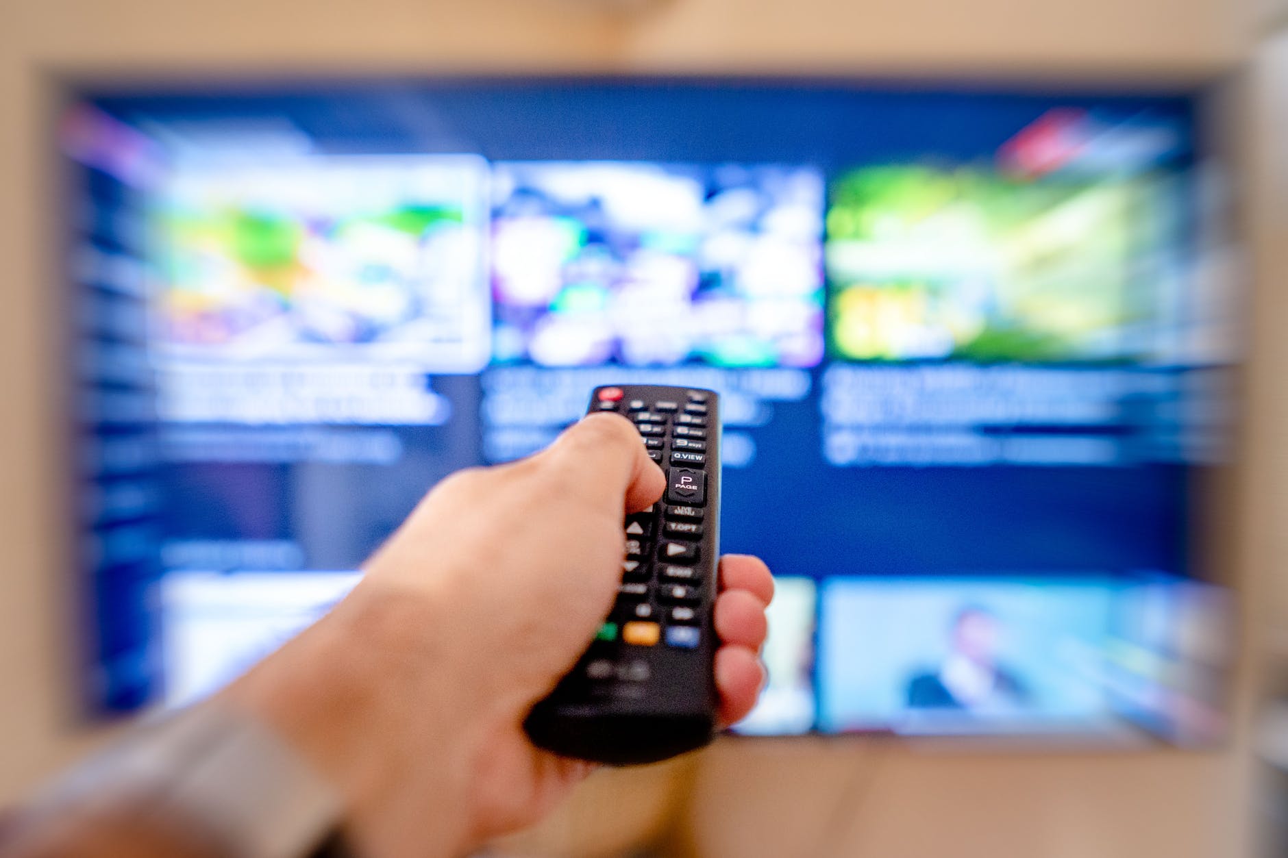 a close up shot of a person using a tv remote controller