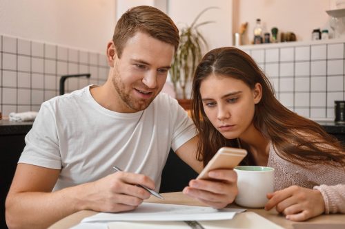 huishoudbudget koppel aan de keukentafel met papier en rekenmachine