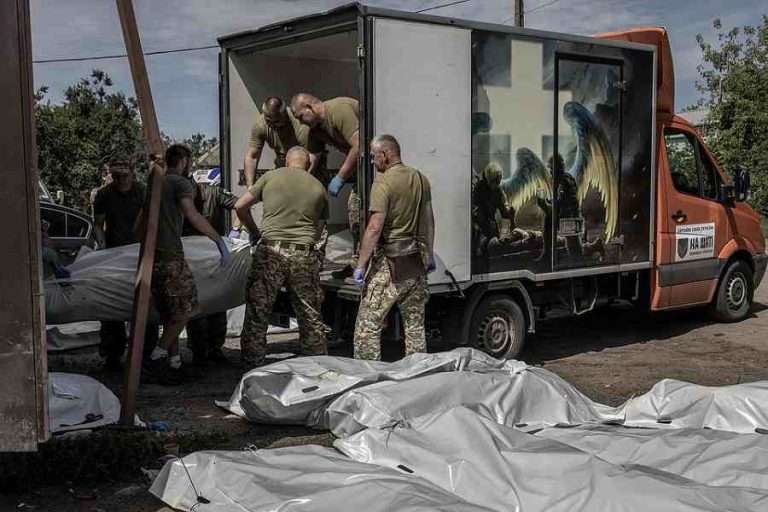 Werklui laden de lichamen van gesneuvelde Oekraïense soldaten op in een lijkwagen, in de regio van Donetsk. © Finbarr O’Reilly/nyt