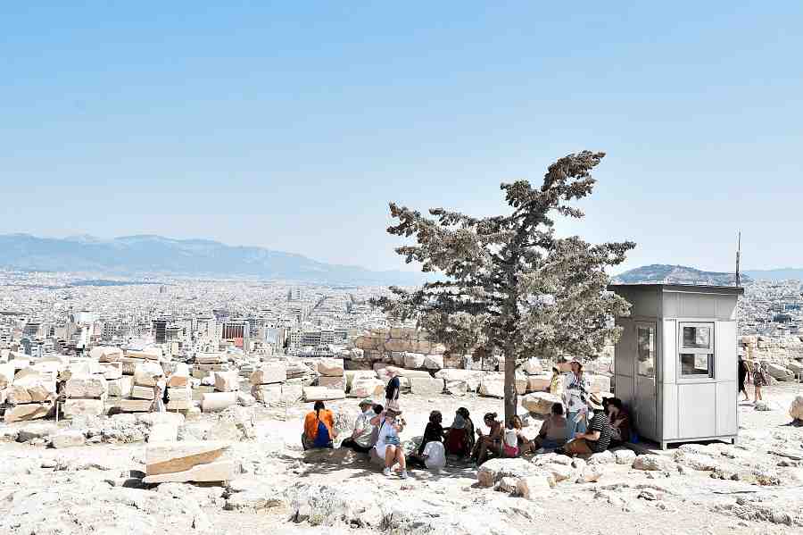 Toeristen in Athene zoeken tijdens een hittegolf de schaarse schaduw op in de heuvels bij de Akropolis, juli vorig jaar. Beeld Getty Images