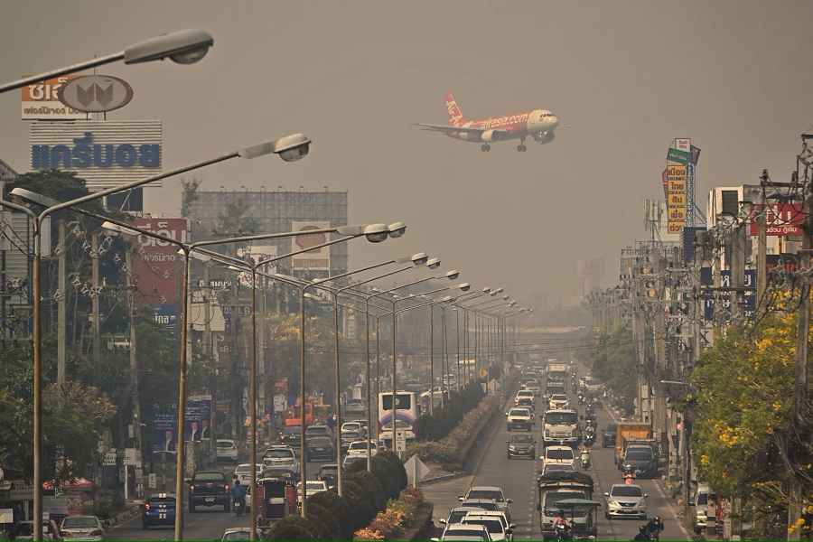 Een vliegtuig van Air Asia vliegt door ernstig vervuilde lucht naar Chiang Mai International Airport in Thailand. Beeld AFP