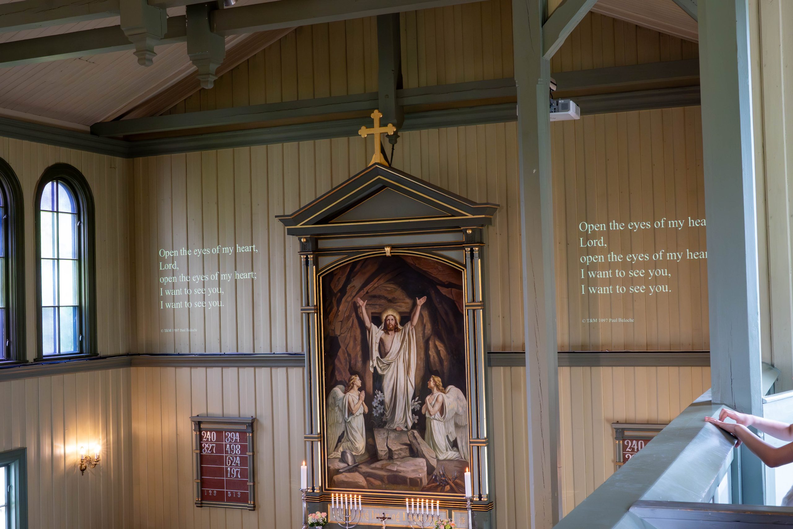 Birkenes kirke interiør med projisering av salmetekst på veggen Konfirmasjonsgudstjeneste. Organisten har korallens melodi og spiller den. Her er teksten projisert på veggen, så menigheten lett kan lese den og ikke behøver salmebok.