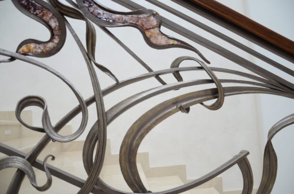 Smeedijzeren balustrade met houten leuning en decoratief glas “Murano” detail