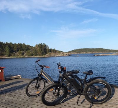 Dam och herrcykel på bryggan vid havet