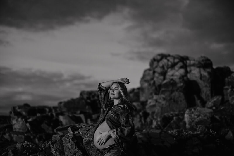 Svartvit gravidfotografering i Skåne vid Hovs Hallar – gravid kvinna i dramatiskt landskap
