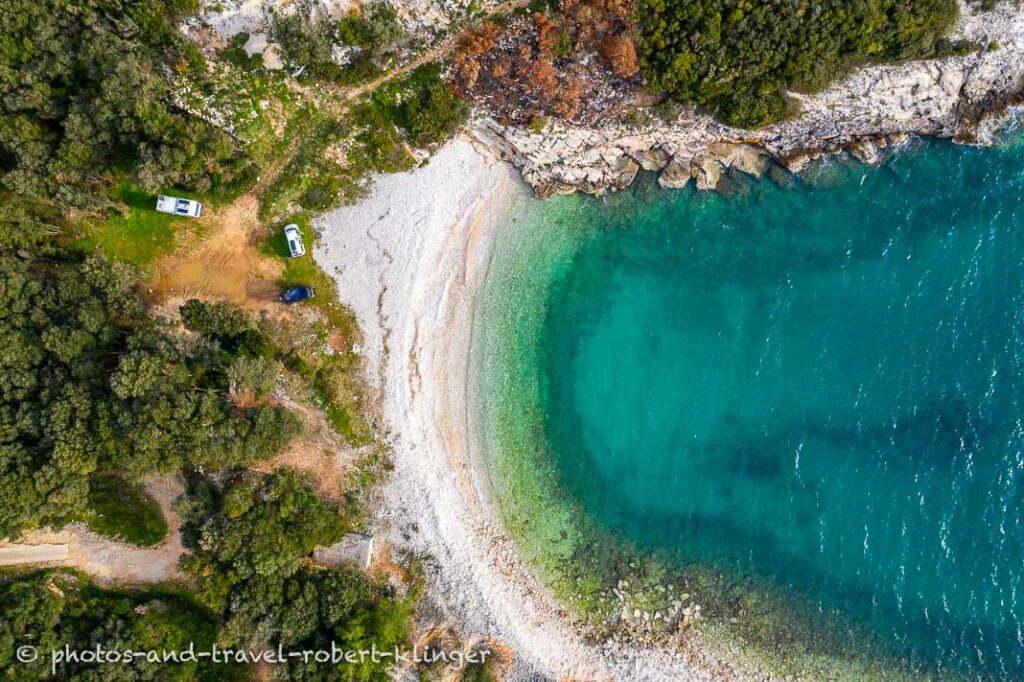 A camping spot in Istria in a bay is used by three vehicles