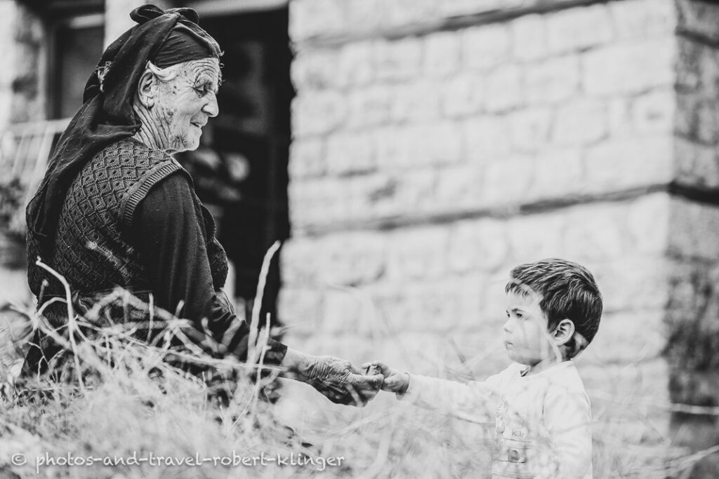A grandmother playing with her grandson in Albania, A vendor in his shop in Albania, black and white photo