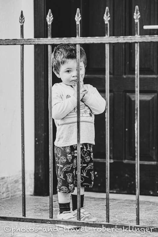A boy behind a grid in Albania, A vendor in his shop in Albania, black and white photo