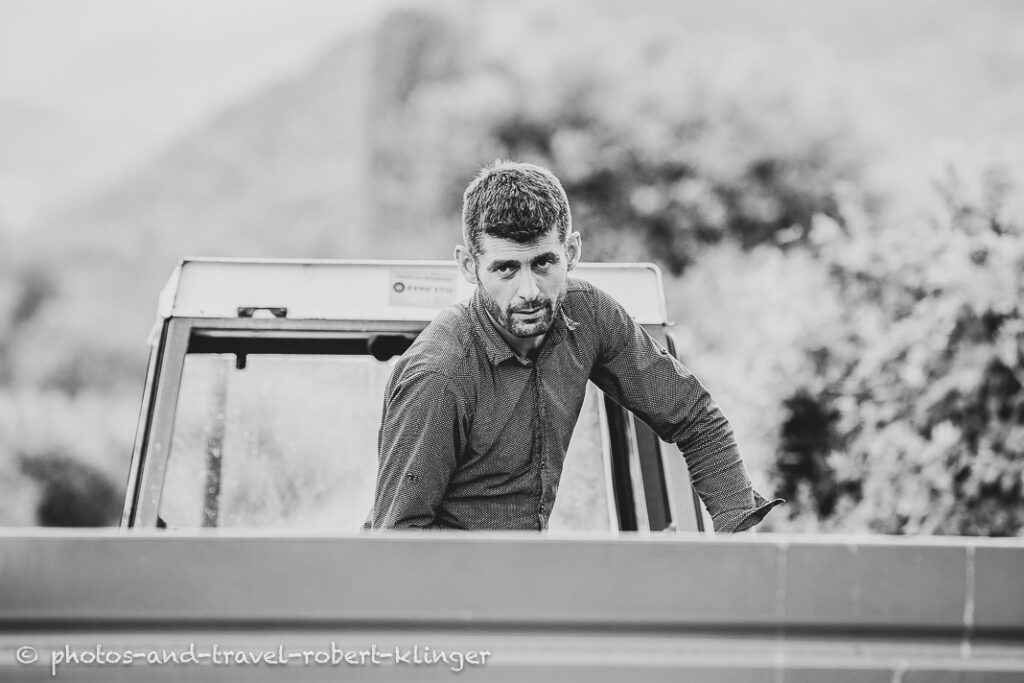 A black and white portrait of a man on a tractor
