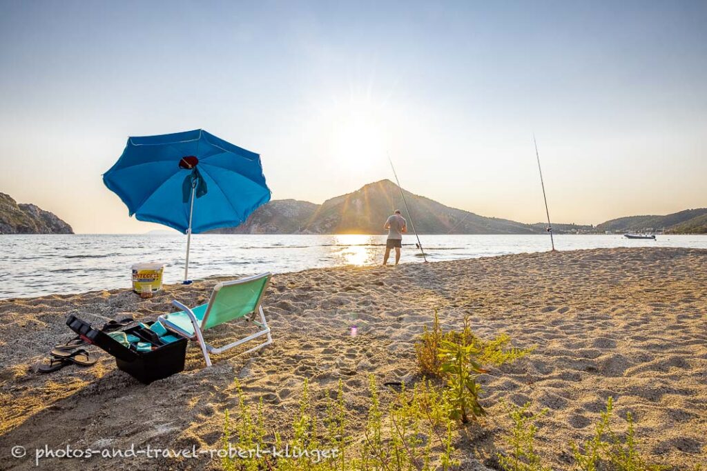 A man is fishing on a beach in Sithonia, Greece