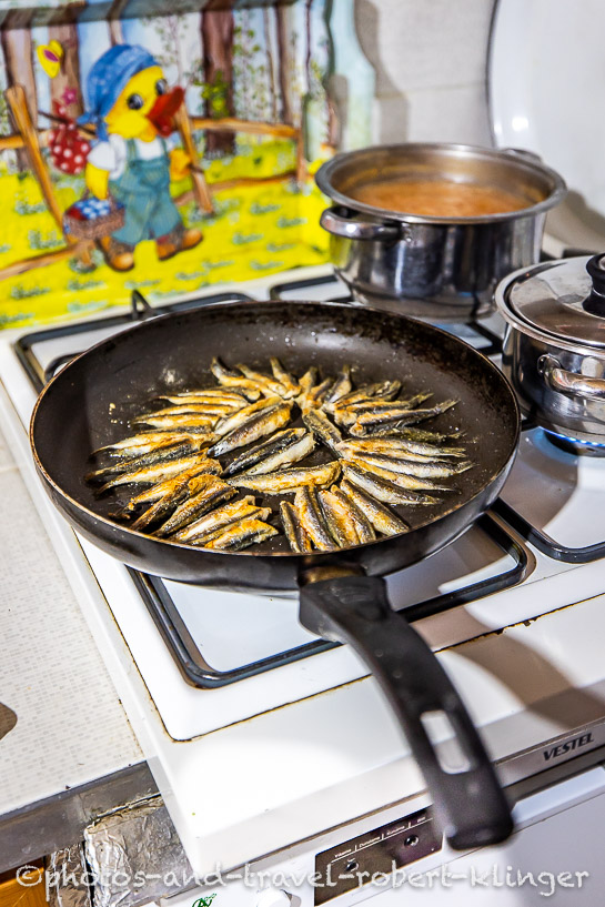 Fish being fried in a pan in a kitchen in a turkish village