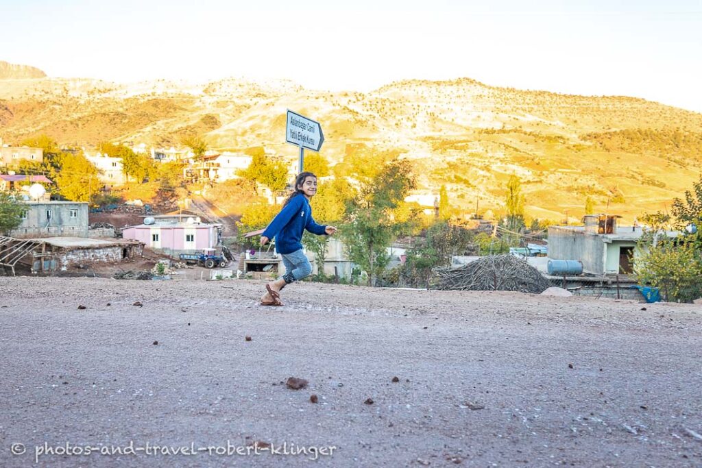 A girl running through a village in Kurdistane, Turkey