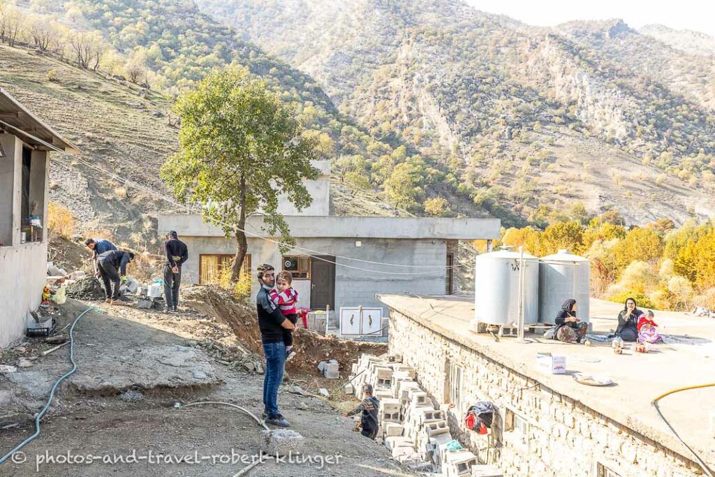 Men working on a construction site in Kurdistan and two women having a rest