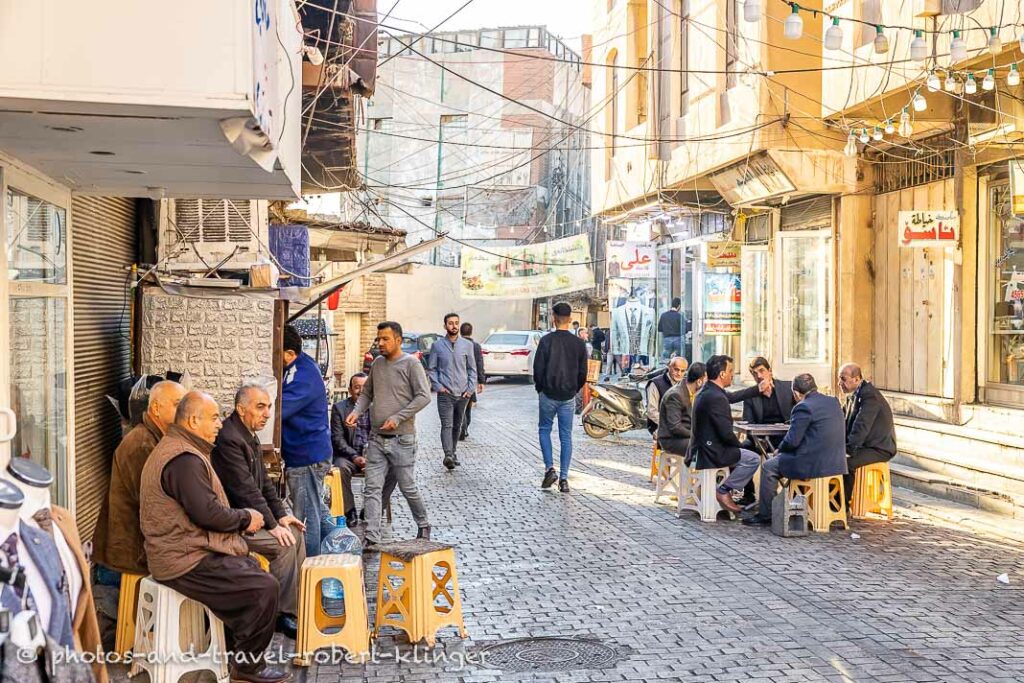 Many men are sitting beside a street in Erbil, Kurdistan