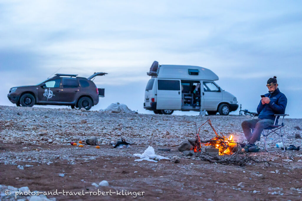 A traveller sitting at the campfire at Lake Dukan