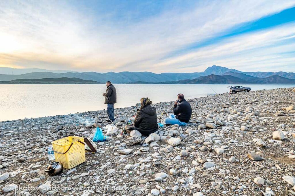 Three kurdish men sitting around a campfire at Lake Dukan