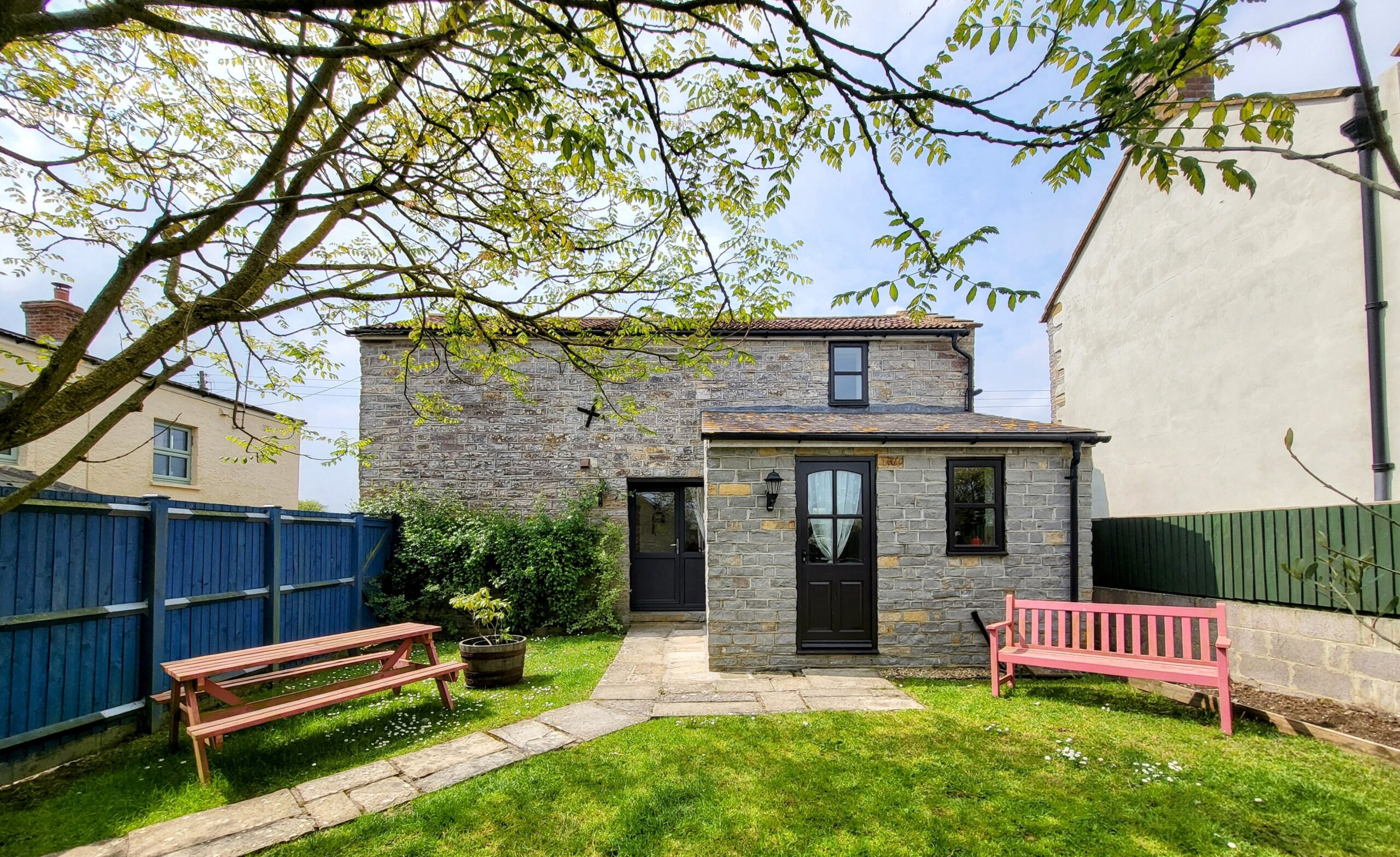 Barn Cottage... Grassed garden with pink benches - Barn Cottage