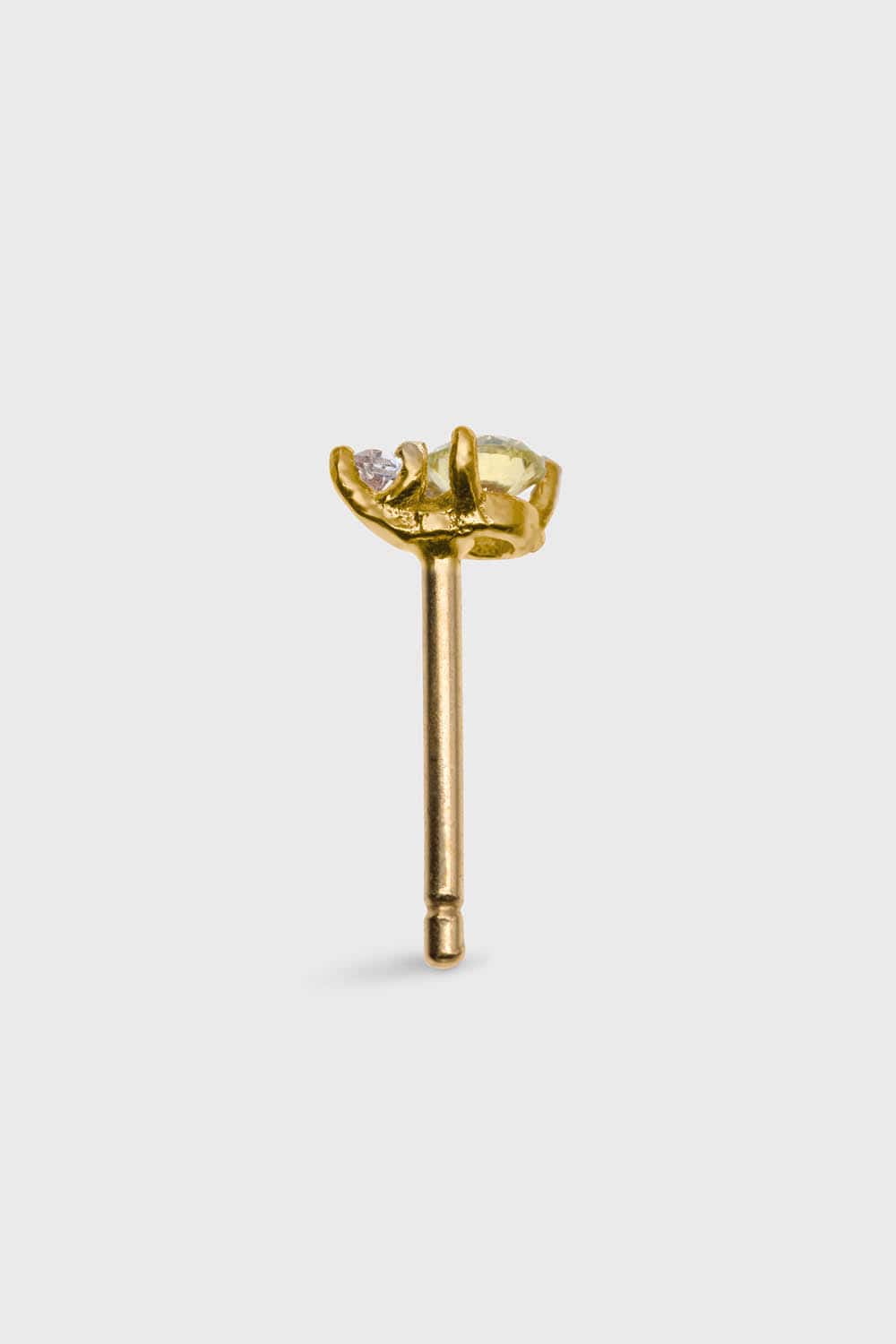 SIDE VIEW OF PLANCTOLOGY® DRIFTER 9. TINY 14K SOLID GOLD STUD EARRING WITH ONE CLEAR AND ONE LIGHT YELLOW, GREENISH ROUND CUT STONE.