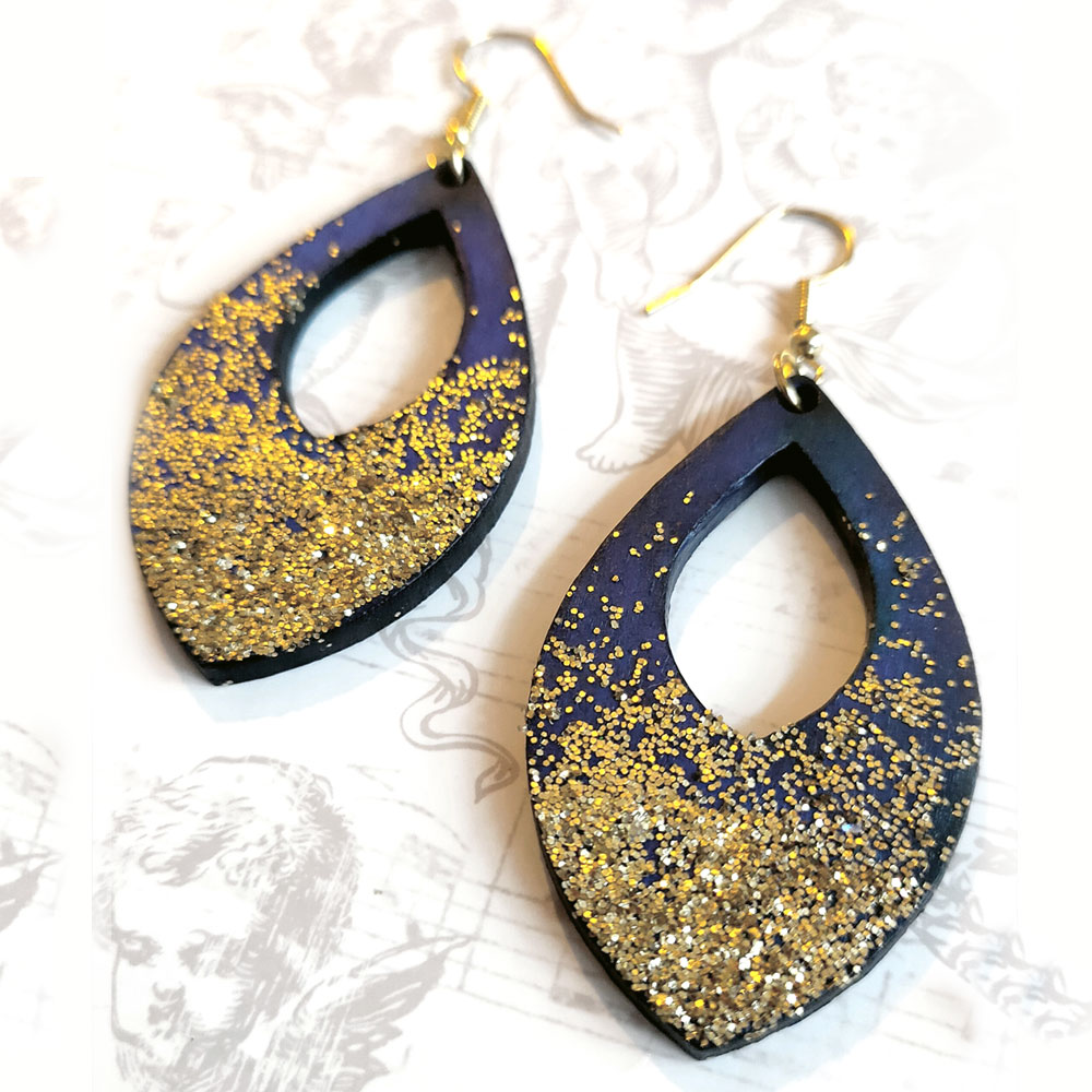 Dark blue earrings with gold glitter sprinkling upwards.